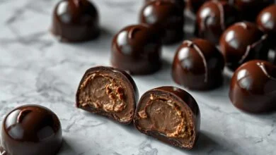 Quanto Tempo Para O Chocolate Endurecer: Guia Completo 53 Bombons de chocolate escuro com superfície brilhante, lisa e sem manchas brancas, demonstrando o resultado ideal da temperagem.