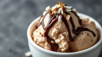 Sorvete Prestígio Cremoso: Fácil E Sem Máquina 48 Porção generosa de sorvete prestígio cremoso em tigela de cerâmica, com calda de chocolate e flocos de coco.
