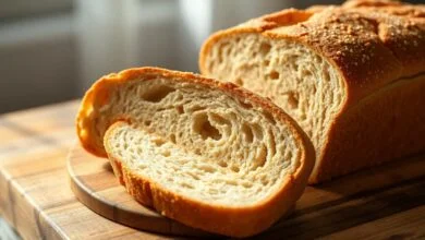 Pão Integral Fofinho: Receita Fácil E Saudável Que Não Seca 42 Pão integral alto e dourado, fatiado sobre uma tábua rústica com miolo macio visível.